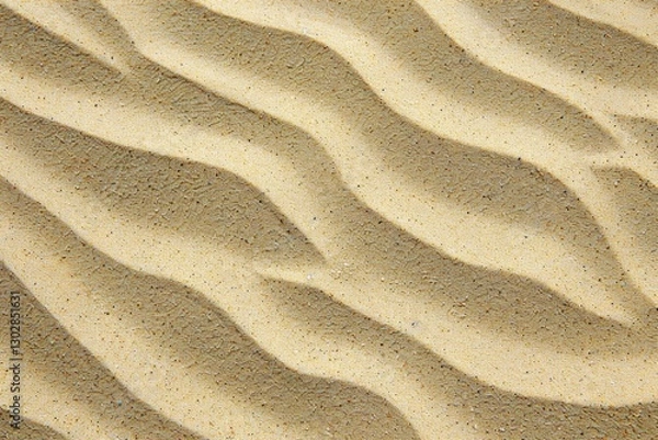 Fototapeta Close-up of textured sand dunes with smooth wind-formed patterns. Natural desert surface background.