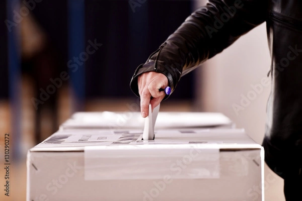 Obraz Hand casting a vote into the ballot box