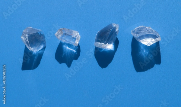 Fototapeta Ice cubes with water drops on light blue background,hard light with shadows