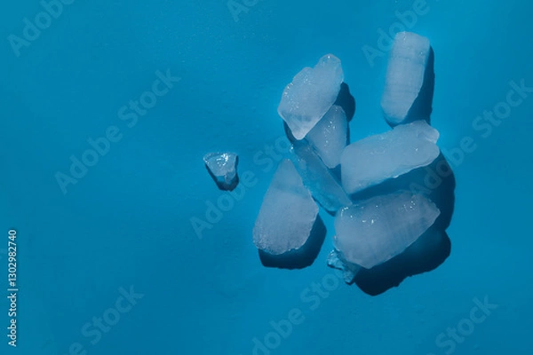 Fototapeta Ice cubes with water drops on light blue background,hard light with shadows