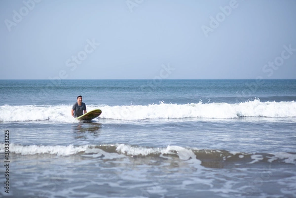 Fototapeta A man on a vacation surfs on a board in the ocean