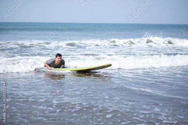 Fototapeta A man on a vacation surfs on a board in the ocean