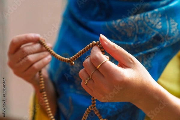 Obraz Muslim woman holding rosary and praying in mosque