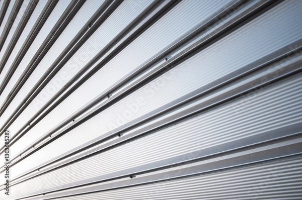 Fototapeta Metallic roller shutter door closed security in modern wharehouse