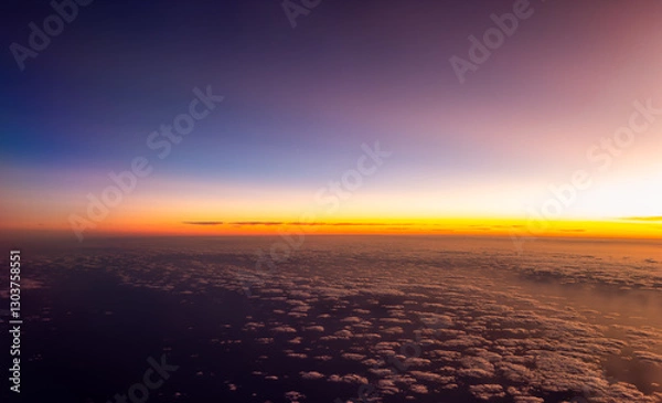Fototapeta A sunset as seen from a plane flying high above the clouds in Australia
