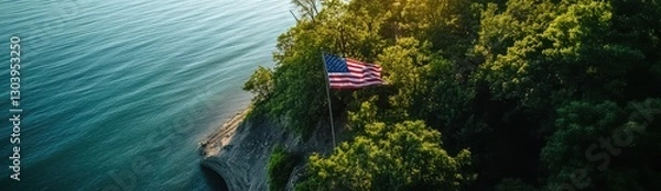 Obraz An American flag is flying on the cliff overlooking Lake Michigan, an aerial view captured by a drone.