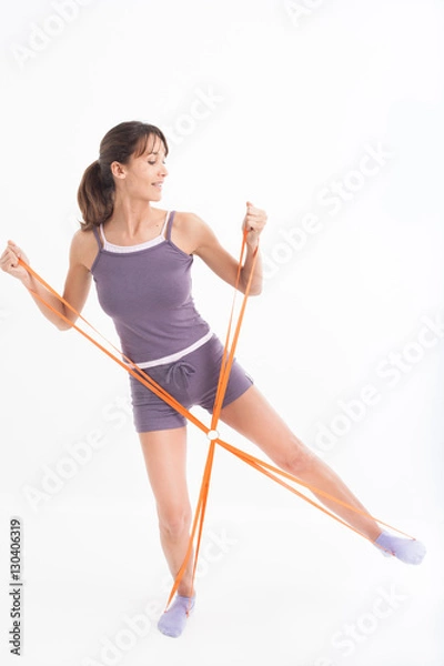 Fototapeta femme souriant qui fait des exercices sportifs avec un élastique