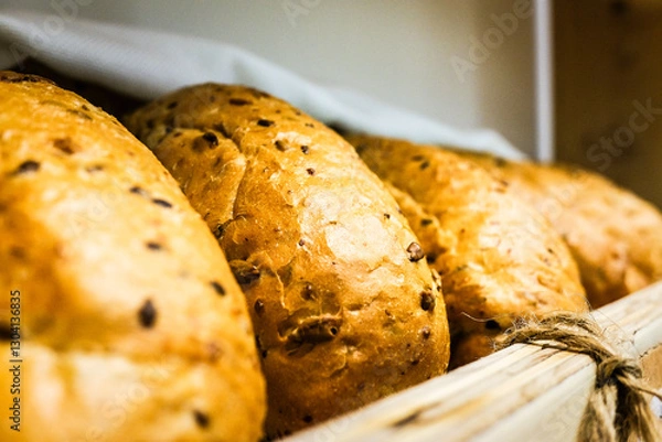 Obraz Fresh, freshly baked round bread with seeds on a bakery shelf
