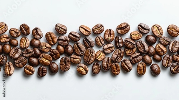 Obraz Roasted coffee beans scattered along a solid colored background