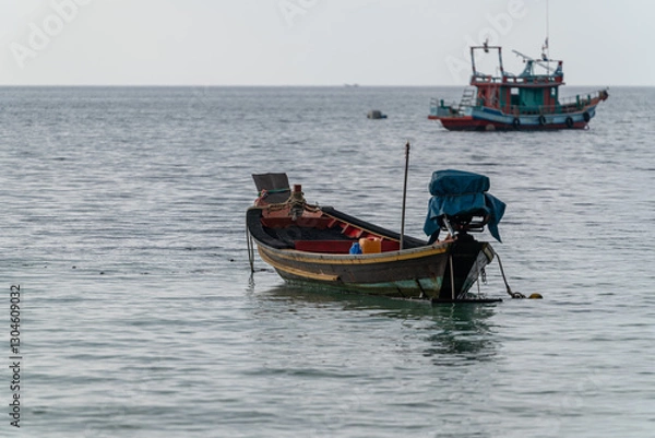 Obraz A longtail boat in a bay in the south of Thailand, a fishing vessel in the background
