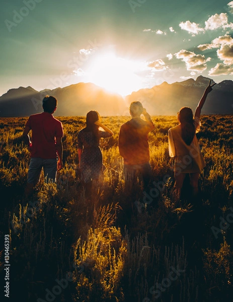 Obraz Multiracial group of people stand looking at sunset. Backlight shot. Happiness, success, friendship and community concepts. In Grand Teton National Park, Montana