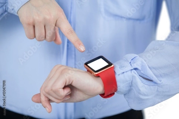 Fototapeta Mid section of businesswoman using smartwatch