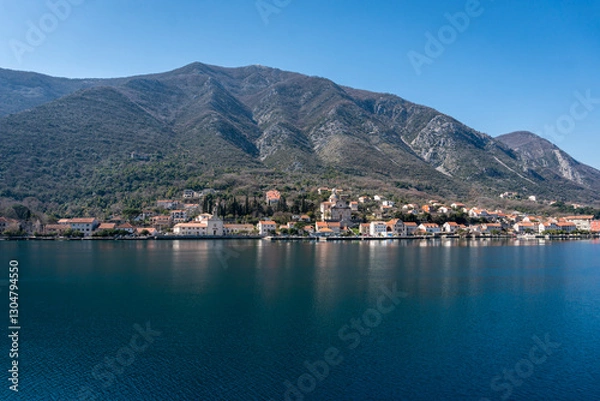 Fototapeta View of a small town with a backdrop of mountains in Kotor bay, Montenegro