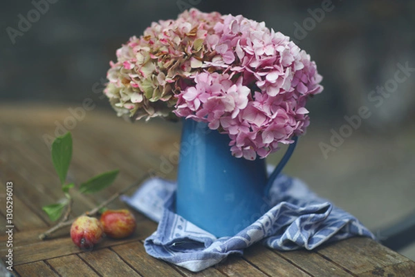 Obraz Still life with hydrangeas in a vase, captured in warm natural light. Soft tones and delicate petals create a calm, elegant and timeless floral composition.
