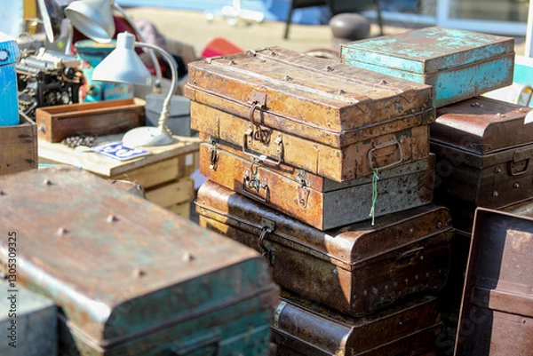 Obraz Lively flea market scene in France with vintage items, antiques, books, and decorations. People browsing and enjoying the atmosphere on a sunny day. European market culture captured in detail.