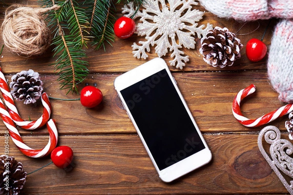 Fototapeta Smart phone mock up with rustic Christmas decorations for app presentation. View from above