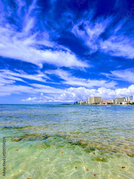 Fototapeta Stunning view of Waikiki Beach and clear waters of Oahu during a sunny day with vibrant clouds above