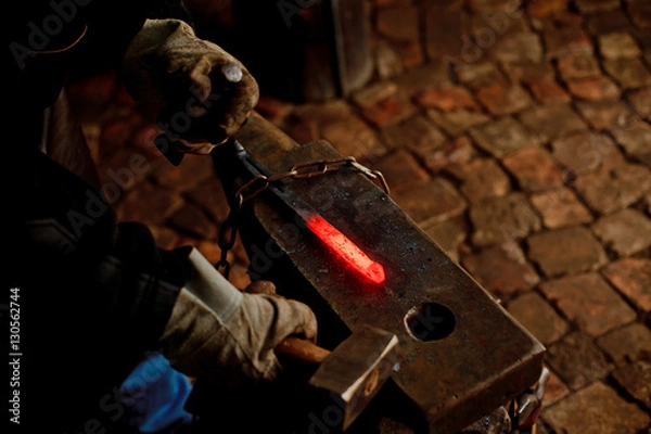 Obraz The blacksmith manually forging the molten metal