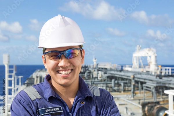 Obraz Smiling asian engineer in white helmet.