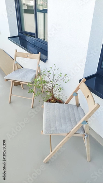 Fototapeta Two folding chairs with cushions on modern balcony in prague