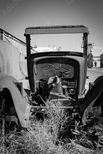 Fototapeta Front view of the remains of an antique Model T flatbed truck in black and white.