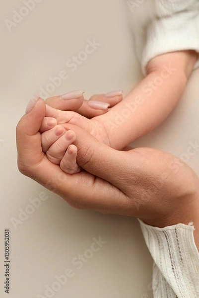Fototapeta Close-up little hand of child and palm of mother and father. The newborn baby has a firm grip on the parent's finger after birth. A newborn holds on to mom's, dad's finger. 