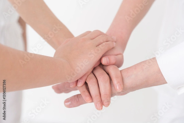Obraz 子供と大人が手を重ねている。/白背景スタジオ撮影