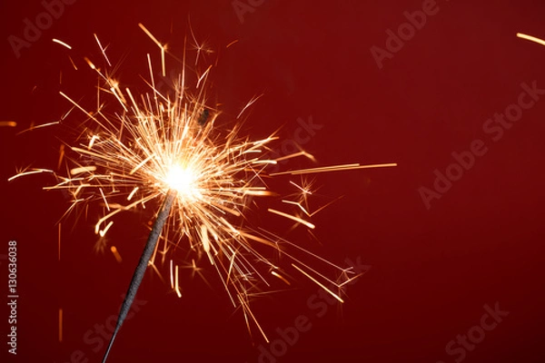 Obraz Flaming sparkler on red background