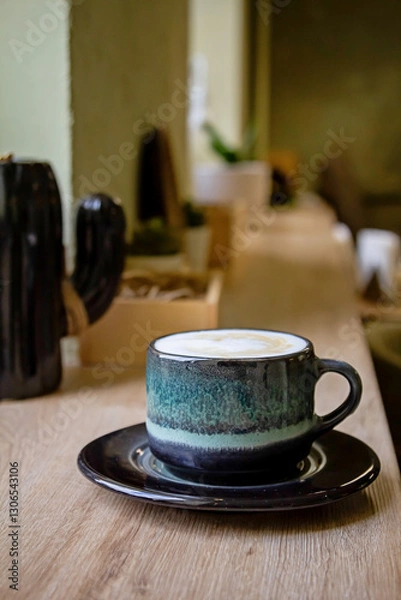 Obraz Coffee in blue cup on brown wooden table background top view. Morning in a cafe with a cup of cappuccino