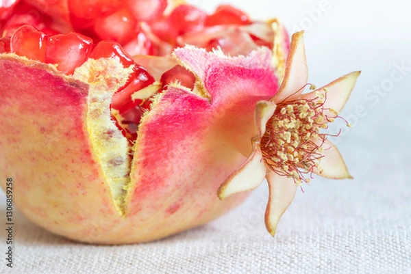 Obraz Close up of a cracked ripe pomegranate fruit with red seeds. Macro view Punica granatum Lythraceae. Selective focus. background of a light tablecloth