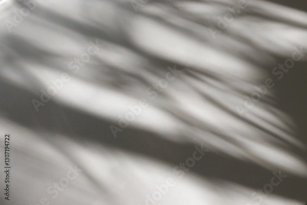 Fototapeta play of light and shadow, soft blurred shadow silhouettes fall on a light surface creating an abstract pattern. space for text.High quality photo