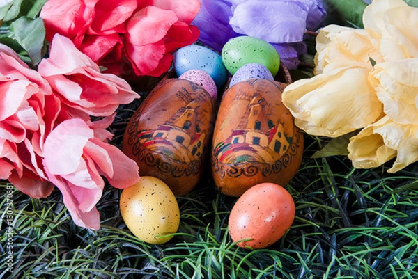 Obraz old wooden shoes in green grass with colored Easter eggs and tulips