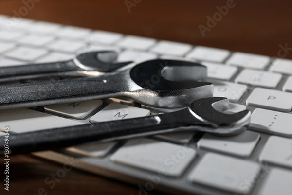Fototapeta Technical support concept. Wrenches and keyboard on wooden background, closeup