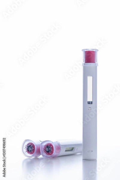 Fototapeta A group of pen injectors with a red tip for biological treatments such as Adalimumab, Etanercept or epinephrine. One is standing on a white light background, aseptic, clean, white and well lit.