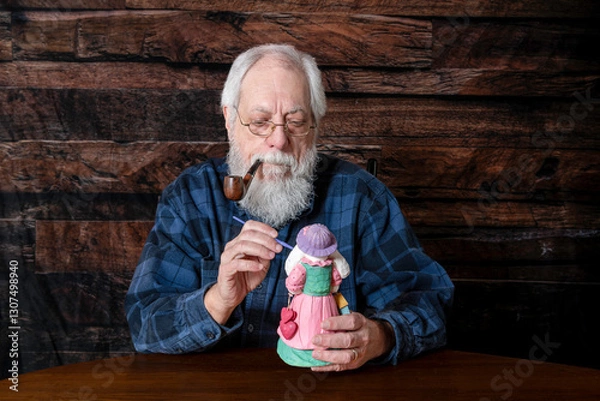 Obraz senior man with white beard smoking pipe painting Easter bunny with wood blank background