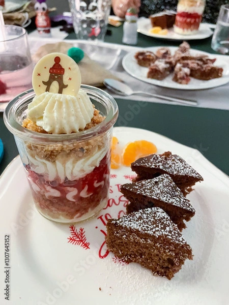 Obraz Dessert im Gläschen mit Sahne, Beerenmousse und Hafercrunch, auf einem Teller mit Gewürzkuchen in Tannenbaum Form serviert
