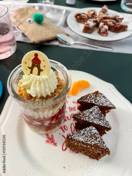 Obraz Dessert im Gläschen mit Sahne, Beerenmousse und Hafercrunch, auf einem Teller mit Gewürzkuchen in Tannenbaum Form serviert