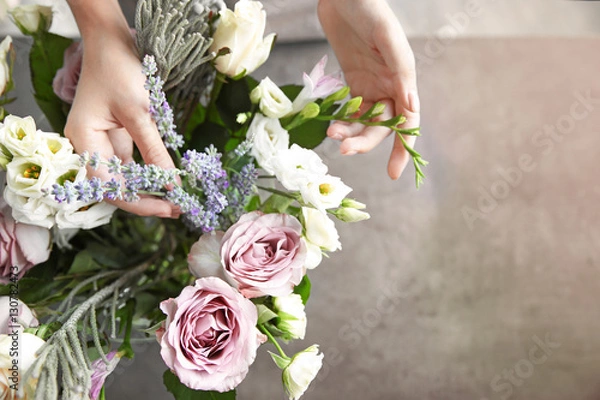 Obraz Kobieta kwiaciarnia robi piękny bukiet w kwiaciarni