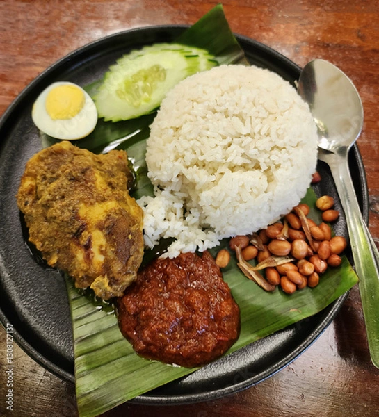 Obraz Traditional Malay dish. Nasi Lemak. Usually fragrant coconut milk pandan rice comes with sambal anchovies, fried peanuts, cucumber slices, egg and choice of beef rendang or dry curry chicken meat