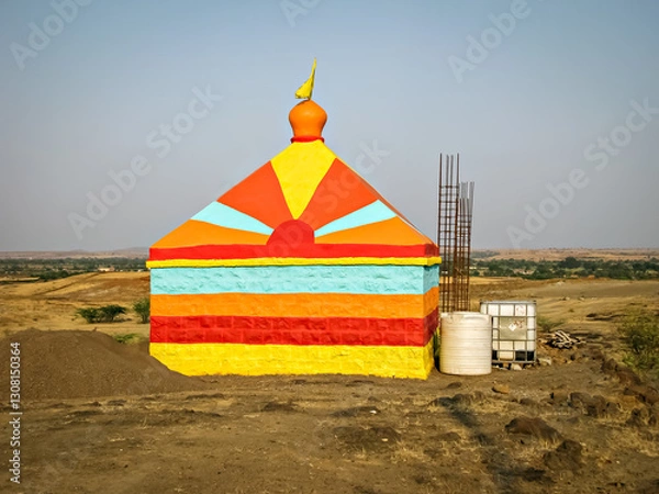 Obraz Colorful isolated image of a colorful temple in construction, on the background of nice blue sky in the outskirts of village.