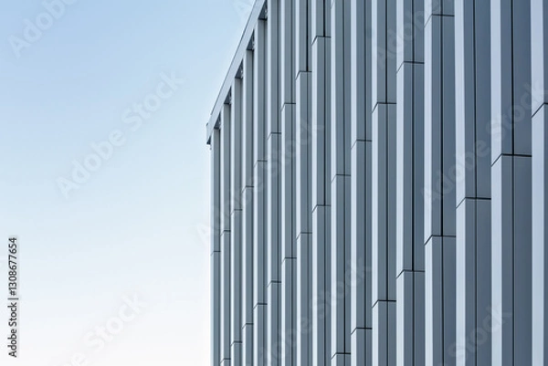 Obraz Close-up of a high-rise facade with repeating vertical panels forming a dynamic geometric pattern. Minimalist urban design.