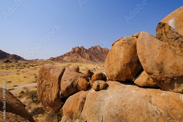 Obraz A stunning view of Spitzkoppe from the granite rocks of Damaraland, Namibia, under a clear blue sky.
