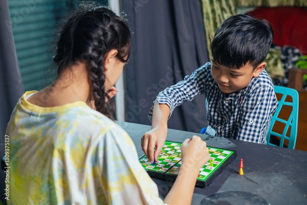 Fototapeta Smart kids enjoying a board game, making their next move in a friendly chess match.