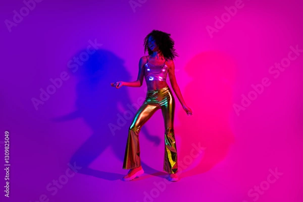 Fototapeta Young stylish woman dancing in glowing neon lights wearing shiny retro-inspired outfit celebrating nightlife and self-expression
