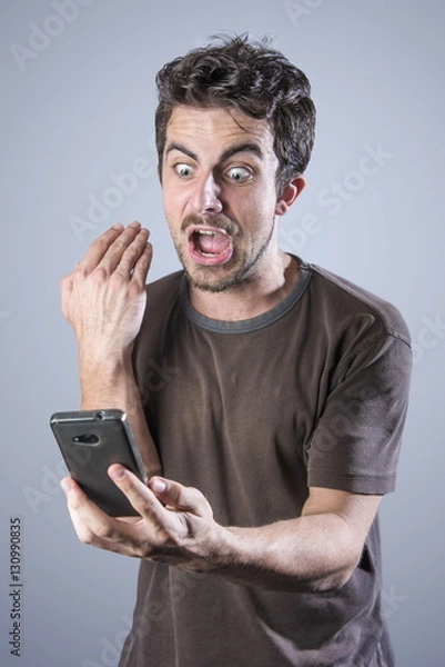 Fototapeta Stressed angry man is shouting at his cell phone, irritated with the service