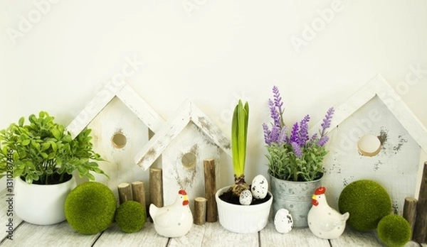 Obraz Easter decorative composition, home decoration for the bright Easter holiday. On a light background, cute chickens and wooden houses, front view, Easter style.
