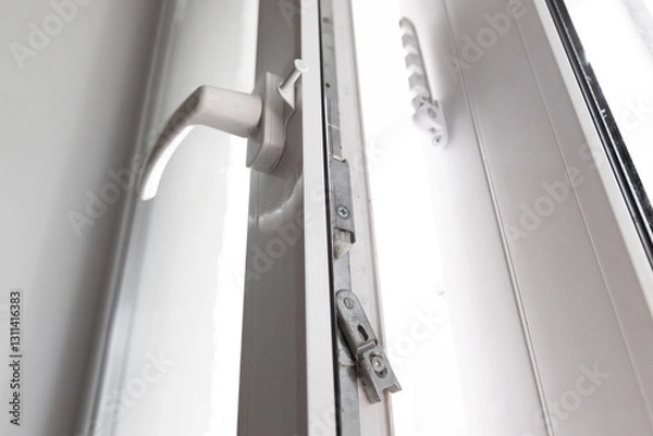 Fototapeta Close-up of a double-glazed balcony frame with a latch and fastening for safe ventilation. Single-sided window handle