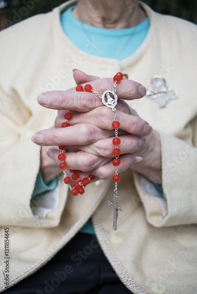 Obraz close-up Rosary in praying clasped wrinkled hands of elderly female. christianity. Horizontal