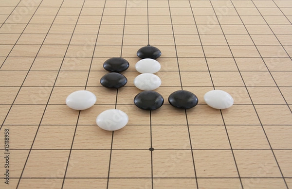 Obraz Schwarze und weiße Go-Steine auf Brett