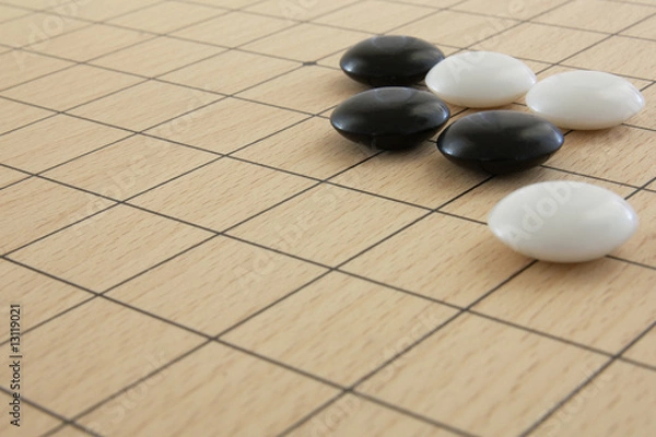 Obraz Schwarze und weiße Go-Steine auf Brett